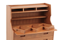 チーク材天然木のライティングビューロです。北欧では昔から馴染みのあるビューロは、チェストとして、ドレッサーとして、そしてデスクとしてなど、1台で非常に機能的なのが特徴で、ワンルームや小さめの部屋にも1台あると便利です。デザインも個性的で存在感があります。引き出しやカーブなど非常に丁寧に作り上げました。