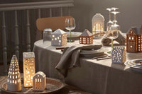 アーバニアは Urban( 都市、都会) が語源のシリーズ。今日も世界のどこかで新たな建物が建てられ、変わっていく現代の街並みと同じように、アーバニアの種類もどんどん広がっています。1 つ1 つハンドメイドでくり抜かれた窓からは、温かく優しい光が漏れだします。夜だけでなく、まだ少し薄暗い朝の時間や夕暮れ時など、時間によって少しずつ表情を変えていくキャンドルの街並みを眺めながら、家の中でゆっくりと流れる時間を楽しんでみるのもおすすめです。