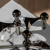 Stoff(ストッフ)は、デンマーク発のデザインブランドで、1960年代の名作「Stoff Nagel(ストッフ・ナゲル)」キャンドルホルダーの復刻から始まりました。建築家Werner Stoff(ヴェルナー・ストッフ)と、ドイツのHans Nagel(ハンス・ナゲル)によって生み出されたこのモジュール式キャンドルホルダーは、彫刻のような幾何学美と、自由な組み合わせによる創造性を兼ね備えたインテリアアートです。現在のStoffは、オリジナルの精神を受け継ぎながら、現代のライフスタイルに合う素材や仕上げを追加し、キャンドルホルダーだけでなくフラワーベースやボウル、ウォールハンガーなど洗練されたアイテムを展開。ミッドセンチュリーや北欧インテリアに調和し、空間に立体感と静謐な存在感を与えます。構築と装飾の境界を超えたStoffの作品は、機能性と造形美が共存する稀有なプロダクトです。