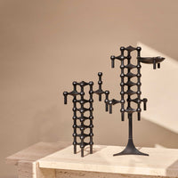 Stoff(ストッフ)は、デンマーク発のデザインブランドで、1960年代の名作「Stoff Nagel(ストッフ・ナゲル)」キャンドルホルダーの復刻から始まりました。建築家Werner Stoff(ヴェルナー・ストッフ)と、ドイツのHans Nagel(ハンス・ナゲル)によって生み出されたこのモジュール式キャンドルホルダーは、彫刻のような幾何学美と、自由な組み合わせによる創造性を兼ね備えたインテリアアートです。現在のStoffは、オリジナルの精神を受け継ぎながら、現代のライフスタイルに合う素材や仕上げを追加し、キャンドルホルダーだけでなくフラワーベースやボウル、ウォールハンガーなど洗練されたアイテムを展開。ミッドセンチュリーや北欧インテリアに調和し、空間に立体感と静謐な存在感を与えます。構築と装飾の境界を超えたStoffの作品は、機能性と造形美が共存する稀有なプロダクトです。