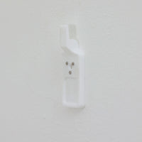 北欧スウェーデンのブランド「BOLD」が開発した、革新的なピクチャーフックです。従来の金属製フックとは異なり、軽量で耐久性の高いプラスチック製を採用。壁へのダメージを最小限に抑えながら、アートや額縁を美しく、確実に掛けることができます。取り付けは驚くほど簡単で、ドリルやアンカーを使わず、付属の細いスチールピンをハンマーで打ち込むだけ。数秒で設置でき、外した跡もほとんど目立ちません。一般的な石こうボードや木壁はもちろん、コンクリート壁にも対応します。素材には柔軟性と高い衝撃吸収性を兼ね備えた熱可塑性プラスチックを採用。フレームをしっかり支えながらも、壁面や釘への負担を軽減します。北欧らしい機能美と合理性を追求したBOLDのピクチャーフックは、壁にアートを飾るという日常の動作を、より簡単でスマートな体験へと変えてくれます。