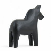 Grannas A. Olsson Hemslojd(グランナス オルソン ヘムスロイド)は、1922年にスウェーデン・ダーラナ地方ヌスナスで創業した世界最古のダラホース工房です。創業者のアンダース オルソン氏は、当初家族経営のパン屋から木工品製造へと転換し、弟らと協力してダラホースの生産を始めました。ひとつずつ選別されたスロースギ材(シルヤン湖周辺の赤松)を使い、木型の挽きから手彫り、下地塗装、さらに熟練のリップル(波模様)ペインターによるフリーハンド装飾を施します。その後、丁寧にニス仕上げされ、赤や白、青など伝統色に彩られた馬たちは、まさに「スウェーデンの象徴」として世界中の家庭や店舗に愛されています。伝統工房としての格式を受け継ぎつつも、パステルやモノトーン、限定柄などを加えることで、現代のインテリアにもマッチするデザイン性も追求しています。