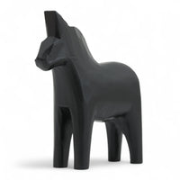 Grannas A. Olsson Hemslojd(グランナス オルソン ヘムスロイド)は、1922年にスウェーデン・ダーラナ地方ヌスナスで創業した世界最古のダラホース工房です。創業者のアンダース オルソン氏は、当初家族経営のパン屋から木工品製造へと転換し、弟らと協力してダラホースの生産を始めました。ひとつずつ選別されたスロースギ材(シルヤン湖周辺の赤松)を使い、木型の挽きから手彫り、下地塗装、さらに熟練のリップル(波模様)ペインターによるフリーハンド装飾を施します。その後、丁寧にニス仕上げされ、赤や白、青など伝統色に彩られた馬たちは、まさに「スウェーデンの象徴」として世界中の家庭や店舗に愛されています。伝統工房としての格式を受け継ぎつつも、パステルやモノトーン、限定柄などを加えることで、現代のインテリアにもマッチするデザイン性も追求しています。