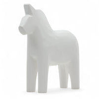 Grannas A. Olsson Hemslojd(グランナス オルソン ヘムスロイド)は、1922年にスウェーデン・ダーラナ地方ヌスナスで創業した世界最古のダラホース工房です。創業者のアンダース オルソン氏は、当初家族経営のパン屋から木工品製造へと転換し、弟らと協力してダラホースの生産を始めました。ひとつずつ選別されたスロースギ材(シルヤン湖周辺の赤松)を使い、木型の挽きから手彫り、下地塗装、さらに熟練のリップル(波模様)ペインターによるフリーハンド装飾を施します。その後、丁寧にニス仕上げされ、赤や白、青など伝統色に彩られた馬たちは、まさに「スウェーデンの象徴」として世界中の家庭や店舗に愛されています。伝統工房としての格式を受け継ぎつつも、パステルやモノトーン、限定柄などを加えることで、現代のインテリアにもマッチするデザイン性も追求しています。