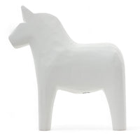 Grannas A. Olsson Hemslojd(グランナス オルソン ヘムスロイド)は、1922年にスウェーデン・ダーラナ地方ヌスナスで創業した世界最古のダラホース工房です。創業者のアンダース オルソン氏は、当初家族経営のパン屋から木工品製造へと転換し、弟らと協力してダラホースの生産を始めました。ひとつずつ選別されたスロースギ材(シルヤン湖周辺の赤松)を使い、木型の挽きから手彫り、下地塗装、さらに熟練のリップル(波模様)ペインターによるフリーハンド装飾を施します。その後、丁寧にニス仕上げされ、赤や白、青など伝統色に彩られた馬たちは、まさに「スウェーデンの象徴」として世界中の家庭や店舗に愛されています。伝統工房としての格式を受け継ぎつつも、パステルやモノトーン、限定柄などを加えることで、現代のインテリアにもマッチするデザイン性も追求しています。