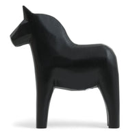 Grannas A. Olsson Hemslojd(グランナス オルソン ヘムスロイド)は、1922年にスウェーデン・ダーラナ地方ヌスナスで創業した世界最古のダラホース工房です。創業者のアンダース オルソン氏は、当初家族経営のパン屋から木工品製造へと転換し、弟らと協力してダラホースの生産を始めました。ひとつずつ選別されたスロースギ材(シルヤン湖周辺の赤松)を使い、木型の挽きから手彫り、下地塗装、さらに熟練のリップル(波模様)ペインターによるフリーハンド装飾を施します。その後、丁寧にニス仕上げされ、赤や白、青など伝統色に彩られた馬たちは、まさに「スウェーデンの象徴」として世界中の家庭や店舗に愛されています。伝統工房としての格式を受け継ぎつつも、パステルやモノトーン、限定柄などを加えることで、現代のインテリアにもマッチするデザイン性も追求しています。