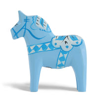 Grannas A. Olsson Hemslojd(グランナス オルソン ヘムスロイド)は、1922年にスウェーデン・ダーラナ地方ヌスナスで創業した世界最古のダラホース工房です。創業者のアンダース オルソン氏は、当初家族経営のパン屋から木工品製造へと転換し、弟らと協力してダラホースの生産を始めました。ひとつずつ選別されたスロースギ材(シルヤン湖周辺の赤松)を使い、木型の挽きから手彫り、下地塗装、さらに熟練のリップル(波模様)ペインターによるフリーハンド装飾を施します。その後、丁寧にニス仕上げされ、赤や白、青など伝統色に彩られた馬たちは、まさに「スウェーデンの象徴」として世界中の家庭や店舗に愛されています。伝統工房としての格式を受け継ぎつつも、パステルやモノトーン、限定柄などを加えることで、現代のインテリアにもマッチするデザイン性も追求しています。