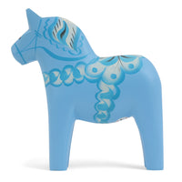 Grannas A. Olsson Hemslojd(グランナス オルソン ヘムスロイド)は、1922年にスウェーデン・ダーラナ地方ヌスナスで創業した世界最古のダラホース工房です。創業者のアンダース オルソン氏は、当初家族経営のパン屋から木工品製造へと転換し、弟らと協力してダラホースの生産を始めました。ひとつずつ選別されたスロースギ材(シルヤン湖周辺の赤松)を使い、木型の挽きから手彫り、下地塗装、さらに熟練のリップル(波模様)ペインターによるフリーハンド装飾を施します。その後、丁寧にニス仕上げされ、赤や白、青など伝統色に彩られた馬たちは、まさに「スウェーデンの象徴」として世界中の家庭や店舗に愛されています。伝統工房としての格式を受け継ぎつつも、パステルやモノトーン、限定柄などを加えることで、現代のインテリアにもマッチするデザイン性も追求しています。