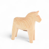 Grannas A. Olsson Hemslojd(グランナス オルソン ヘムスロイド)は、1922年にスウェーデン・ダーラナ地方ヌスナスで創業した世界最古のダラホース工房です。創業者のアンダース オルソン氏は、当初家族経営のパン屋から木工品製造へと転換し、弟らと協力してダラホースの生産を始めました。ひとつずつ選別されたスロースギ材(シルヤン湖周辺の赤松)を使い、木型の挽きから手彫り、下地塗装、さらに熟練のリップル(波模様)ペインターによるフリーハンド装飾を施します。その後、丁寧にニス仕上げされ、赤や白、青など伝統色に彩られた馬たちは、まさに「スウェーデンの象徴」として世界中の家庭や店舗に愛されています。伝統工房としての格式を受け継ぎつつも、パステルやモノトーン、限定柄などを加えることで、現代のインテリアにもマッチするデザイン性も追求しています。