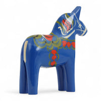 Grannas A. Olsson Hemslojd(グランナス オルソン ヘムスロイド)は、1922年にスウェーデン・ダーラナ地方ヌスナスで創業した世界最古のダラホース工房です。創業者のアンダース オルソン氏は、当初家族経営のパン屋から木工品製造へと転換し、弟らと協力してダラホースの生産を始めました。ひとつずつ選別されたスロースギ材(シルヤン湖周辺の赤松)を使い、木型の挽きから手彫り、下地塗装、さらに熟練のリップル(波模様)ペインターによるフリーハンド装飾を施します。その後、丁寧にニス仕上げされ、赤や白、青など伝統色に彩られた馬たちは、まさに「スウェーデンの象徴」として世界中の家庭や店舗に愛されています。伝統工房としての格式を受け継ぎつつも、パステルやモノトーン、限定柄などを加えることで、現代のインテリアにもマッチするデザイン性も追求しています。