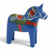 Grannas A. Olsson Hemslojd(グランナス オルソン ヘムスロイド)は、1922年にスウェーデン・ダーラナ地方ヌスナスで創業した世界最古のダラホース工房です。創業者のアンダース オルソン氏は、当初家族経営のパン屋から木工品製造へと転換し、弟らと協力してダラホースの生産を始めました。ひとつずつ選別されたスロースギ材(シルヤン湖周辺の赤松)を使い、木型の挽きから手彫り、下地塗装、さらに熟練のリップル(波模様)ペインターによるフリーハンド装飾を施します。その後、丁寧にニス仕上げされ、赤や白、青など伝統色に彩られた馬たちは、まさに「スウェーデンの象徴」として世界中の家庭や店舗に愛されています。伝統工房としての格式を受け継ぎつつも、パステルやモノトーン、限定柄などを加えることで、現代のインテリアにもマッチするデザイン性も追求しています。