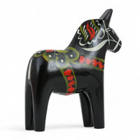 Grannas A. Olsson Hemslojd(グランナス オルソン ヘムスロイド)は、1922年にスウェーデン・ダーラナ地方ヌスナスで創業した世界最古のダラホース工房です。創業者のアンダース オルソン氏は、当初家族経営のパン屋から木工品製造へと転換し、弟らと協力してダラホースの生産を始めました。ひとつずつ選別されたスロースギ材(シルヤン湖周辺の赤松)を使い、木型の挽きから手彫り、下地塗装、さらに熟練のリップル(波模様)ペインターによるフリーハンド装飾を施します。その後、丁寧にニス仕上げされ、赤や白、青など伝統色に彩られた馬たちは、まさに「スウェーデンの象徴」として世界中の家庭や店舗に愛されています。伝統工房としての格式を受け継ぎつつも、パステルやモノトーン、限定柄などを加えることで、現代のインテリアにもマッチするデザイン性も追求しています。