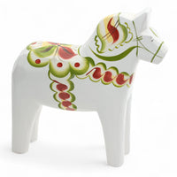 Grannas A. Olsson Hemslojd(グランナス オルソン ヘムスロイド)は、1922年にスウェーデン・ダーラナ地方ヌスナスで創業した世界最古のダラホース工房です。創業者のアンダース オルソン氏は、当初家族経営のパン屋から木工品製造へと転換し、弟らと協力してダラホースの生産を始めました。ひとつずつ選別されたスロースギ材(シルヤン湖周辺の赤松)を使い、木型の挽きから手彫り、下地塗装、さらに熟練のリップル(波模様)ペインターによるフリーハンド装飾を施します。その後、丁寧にニス仕上げされ、赤や白、青など伝統色に彩られた馬たちは、まさに「スウェーデンの象徴」として世界中の家庭や店舗に愛されています。伝統工房としての格式を受け継ぎつつも、パステルやモノトーン、限定柄などを加えることで、現代のインテリアにもマッチするデザイン性も追求しています。