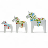 Grannas A. Olsson Hemslojd(グランナス オルソン ヘムスロイド)は、1922年にスウェーデン・ダーラナ地方ヌスナスで創業した世界最古のダラホース工房です。創業者のアンダース オルソン氏は、当初家族経営のパン屋から木工品製造へと転換し、弟らと協力してダラホースの生産を始めました。ひとつずつ選別されたスロースギ材(シルヤン湖周辺の赤松)を使い、木型の挽きから手彫り、下地塗装、さらに熟練のリップル(波模様)ペインターによるフリーハンド装飾を施します。その後、丁寧にニス仕上げされ、赤や白、青など伝統色に彩られた馬たちは、まさに「スウェーデンの象徴」として世界中の家庭や店舗に愛されています。伝統工房としての格式を受け継ぎつつも、パステルやモノトーン、限定柄などを加えることで、現代のインテリアにもマッチするデザイン性も追求しています。