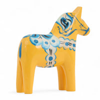 Grannas A. Olsson Hemslojd(グランナス オルソン ヘムスロイド)は、1922年にスウェーデン・ダーラナ地方ヌスナスで創業した世界最古のダラホース工房です。創業者のアンダース オルソン氏は、当初家族経営のパン屋から木工品製造へと転換し、弟らと協力してダラホースの生産を始めました。ひとつずつ選別されたスロースギ材(シルヤン湖周辺の赤松)を使い、木型の挽きから手彫り、下地塗装、さらに熟練のリップル(波模様)ペインターによるフリーハンド装飾を施します。その後、丁寧にニス仕上げされ、赤や白、青など伝統色に彩られた馬たちは、まさに「スウェーデンの象徴」として世界中の家庭や店舗に愛されています。伝統工房としての格式を受け継ぎつつも、パステルやモノトーン、限定柄などを加えることで、現代のインテリアにもマッチするデザイン性も追求しています。