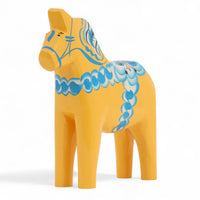 Grannas A. Olsson Hemslojd(グランナス オルソン ヘムスロイド)は、1922年にスウェーデン・ダーラナ地方ヌスナスで創業した世界最古のダラホース工房です。創業者のアンダース オルソン氏は、当初家族経営のパン屋から木工品製造へと転換し、弟らと協力してダラホースの生産を始めました。ひとつずつ選別されたスロースギ材(シルヤン湖周辺の赤松)を使い、木型の挽きから手彫り、下地塗装、さらに熟練のリップル(波模様)ペインターによるフリーハンド装飾を施します。その後、丁寧にニス仕上げされ、赤や白、青など伝統色に彩られた馬たちは、まさに「スウェーデンの象徴」として世界中の家庭や店舗に愛されています。伝統工房としての格式を受け継ぎつつも、パステルやモノトーン、限定柄などを加えることで、現代のインテリアにもマッチするデザイン性も追求しています。