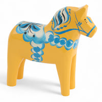 Grannas A. Olsson Hemslojd(グランナス オルソン ヘムスロイド)は、1922年にスウェーデン・ダーラナ地方ヌスナスで創業した世界最古のダラホース工房です。創業者のアンダース オルソン氏は、当初家族経営のパン屋から木工品製造へと転換し、弟らと協力してダラホースの生産を始めました。ひとつずつ選別されたスロースギ材(シルヤン湖周辺の赤松)を使い、木型の挽きから手彫り、下地塗装、さらに熟練のリップル(波模様)ペインターによるフリーハンド装飾を施します。その後、丁寧にニス仕上げされ、赤や白、青など伝統色に彩られた馬たちは、まさに「スウェーデンの象徴」として世界中の家庭や店舗に愛されています。伝統工房としての格式を受け継ぎつつも、パステルやモノトーン、限定柄などを加えることで、現代のインテリアにもマッチするデザイン性も追求しています。