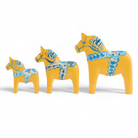 Grannas A. Olsson Hemslojd(グランナス オルソン ヘムスロイド)は、1922年にスウェーデン・ダーラナ地方ヌスナスで創業した世界最古のダラホース工房です。創業者のアンダース オルソン氏は、当初家族経営のパン屋から木工品製造へと転換し、弟らと協力してダラホースの生産を始めました。ひとつずつ選別されたスロースギ材(シルヤン湖周辺の赤松)を使い、木型の挽きから手彫り、下地塗装、さらに熟練のリップル(波模様)ペインターによるフリーハンド装飾を施します。その後、丁寧にニス仕上げされ、赤や白、青など伝統色に彩られた馬たちは、まさに「スウェーデンの象徴」として世界中の家庭や店舗に愛されています。伝統工房としての格式を受け継ぎつつも、パステルやモノトーン、限定柄などを加えることで、現代のインテリアにもマッチするデザイン性も追求しています。