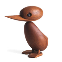 1959年、デンマーク・フレデリクスベアのラッシュアワーのこと。一家のカモがにぎやかな通りに迷い込みました。警官は車と歩行者の交通を止めて、このかわいらしいカモの家族が無事に通れるように道を譲りました。この微笑ましい出来事は、地元新聞の一面を飾り、デンマークの人々の心を魅了しました。この物語に心を打たれたのが、デンマークの建築家ハンス・ブリングです。彼は感動を形にしたいと、この「ダックとダックリング」をデザインしました。窓辺に飾ることができるよう、手作業で作られたチーク無垢材の製品です。頭部は動かすことができ、洗練された美しい仕上がりとなっています。ご自宅で、あなただけのカモの家族を作ってみてください。