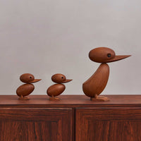 1959年、デンマーク・フレデリクスベアのラッシュアワーのこと。一家のカモがにぎやかな通りに迷い込みました。警官は車と歩行者の交通を止めて、このかわいらしいカモの家族が無事に通れるように道を譲りました。この微笑ましい出来事は、地元新聞の一面を飾り、デンマークの人々の心を魅了しました。この物語に心を打たれたのが、デンマークの建築家ハンス・ブリングです。彼は感動を形にしたいと、この「ダックとダックリング」をデザインしました。窓辺に飾ることができるよう、手作業で作られたチーク無垢材の製品です。頭部は動かすことができ、洗練された美しい仕上がりとなっています。ご自宅で、あなただけのカモの家族を作ってみてください。