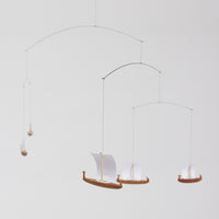 Flensted Mobiles(フレンステッド・モビール)は、1953年創業のデンマーク発・モビール専門ブランド。北欧デザインの文脈に立脚し、造形・質量配分・回転慣性を最適化して、わずかな気流でも自律的に表情を変える構成美を追求します。各パーツは重心とトルクの釣り合いを精密に設計し、静止と運動のあいだを往還する“動く彫刻”として空間に時間軸を付与。代表作「Lucky Storks」から幾何学、鳥類、気球まで多彩で、紙・ステンレス・木材の軽量構造は施工負荷が小さく、住宅・商業・ホスピタリティ・キッズ空間に適合します。現在もデンマーク国内で手作業組立・品質管理を徹底し、視覚ノイズを抑えた運動リズムが集中・鎮静・遊び心をもたらします。北欧インテリアの天井飾りや吊り下げモビールとして、リビング・子供部屋・出産祝いギフトに最適なデンマーク製の正規品です。