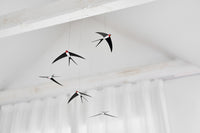 Flensted Hanging Art(フレンステッド・ハンギングアート)は、1954年にデンマークで誕生した北欧モビールの老舗ブランドです。創業者クリスチャン・フレンステッドと妻グレーテが自宅で最初のモビールを作ったことから始まり、現在も家族経営のもと、すべて手作業で丁寧に製作されています。風や空気の流れで繊細に揺れるモビールは、リビングや寝室、子供部屋、玄関、オフィスなど、さまざまな空間に静けさと調和をもたらします。北欧インテリアやモダンアートと調和するシンプルで洗練されたデザインは、出産祝いや引越し祝い、誕生日などのギフトにも最適。2024年にはブランド名を「Flensted mobiles」から「Flensted Hanging Art」へ刷新し、アート性とハンドメイドの温もりをそのままに、より現代的な世界観を発信しています。癒しの空間演出を求める方におすすめのインテリアアートです。