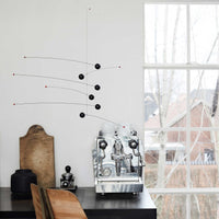 Flensted Mobiles(フレンステッド・モビール)は、1953年創業のデンマーク発・モビール専門ブランド。北欧デザインの文脈に立脚し、造形・質量配分・回転慣性を最適化して、わずかな気流でも自律的に表情を変える構成美を追求します。各パーツは重心とトルクの釣り合いを精密に設計し、静止と運動のあいだを往還する“動く彫刻”として空間に時間軸を付与。代表作「Lucky Storks」から幾何学、鳥類、気球まで多彩で、紙・ステンレス・木材の軽量構造は施工負荷が小さく、住宅・商業・ホスピタリティ・キッズ空間に適合します。現在もデンマーク国内で手作業組立・品質管理を徹底し、視覚ノイズを抑えた運動リズムが集中・鎮静・遊び心をもたらします。北欧インテリアの天井飾りや吊り下げモビールとして、リビング・子供部屋・出産祝いギフトに最適なデンマーク製の正規品です。