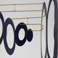 Flensted Mobiles(フレンステッド・モビール)は、1953年創業のデンマーク発・モビール専門ブランド。北欧デザインの文脈に立脚し、造形・質量配分・回転慣性を最適化して、わずかな気流でも自律的に表情を変える構成美を追求します。各パーツは重心とトルクの釣り合いを精密に設計し、静止と運動のあいだを往還する“動く彫刻”として空間に時間軸を付与。代表作「Lucky Storks」から幾何学、鳥類、気球まで多彩で、紙・ステンレス・木材の軽量構造は施工負荷が小さく、住宅・商業・ホスピタリティ・キッズ空間に適合します。現在もデンマーク国内で手作業組立・品質管理を徹底し、視覚ノイズを抑えた運動リズムが集中・鎮静・遊び心をもたらします。北欧インテリアの天井飾りや吊り下げモビールとして、リビング・子供部屋・出産祝いギフトに最適なデンマーク製の正規品です。