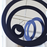 Flensted Mobiles(フレンステッド・モビール)は、1953年創業のデンマーク発・モビール専門ブランド。北欧デザインの文脈に立脚し、造形・質量配分・回転慣性を最適化して、わずかな気流でも自律的に表情を変える構成美を追求します。各パーツは重心とトルクの釣り合いを精密に設計し、静止と運動のあいだを往還する“動く彫刻”として空間に時間軸を付与。代表作「Lucky Storks」から幾何学、鳥類、気球まで多彩で、紙・ステンレス・木材の軽量構造は施工負荷が小さく、住宅・商業・ホスピタリティ・キッズ空間に適合します。現在もデンマーク国内で手作業組立・品質管理を徹底し、視覚ノイズを抑えた運動リズムが集中・鎮静・遊び心をもたらします。北欧インテリアの天井飾りや吊り下げモビールとして、リビング・子供部屋・出産祝いギフトに最適なデンマーク製の正規品です。