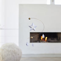 Flensted Mobiles(フレンステッド・モビール)は、1953年創業のデンマーク発・モビール専門ブランド。北欧デザインの文脈に立脚し、造形・質量配分・回転慣性を最適化して、わずかな気流でも自律的に表情を変える構成美を追求します。各パーツは重心とトルクの釣り合いを精密に設計し、静止と運動のあいだを往還する“動く彫刻”として空間に時間軸を付与。代表作「Lucky Storks」から幾何学、鳥類、気球まで多彩で、紙・ステンレス・木材の軽量構造は施工負荷が小さく、住宅・商業・ホスピタリティ・キッズ空間に適合します。現在もデンマーク国内で手作業組立・品質管理を徹底し、視覚ノイズを抑えた運動リズムが集中・鎮静・遊び心をもたらします。北欧インテリアの天井飾りや吊り下げモビールとして、リビング・子供部屋・出産祝いギフトに最適なデンマーク製の正規品です。