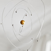 Flensted Mobiles(フレンステッド・モビール)は、1953年創業のデンマーク発・モビール専門ブランド。北欧デザインの文脈に立脚し、造形・質量配分・回転慣性を最適化して、わずかな気流でも自律的に表情を変える構成美を追求します。各パーツは重心とトルクの釣り合いを精密に設計し、静止と運動のあいだを往還する“動く彫刻”として空間に時間軸を付与。代表作「Lucky Storks」から幾何学、鳥類、気球まで多彩で、紙・ステンレス・木材の軽量構造は施工負荷が小さく、住宅・商業・ホスピタリティ・キッズ空間に適合します。現在もデンマーク国内で手作業組立・品質管理を徹底し、視覚ノイズを抑えた運動リズムが集中・鎮静・遊び心をもたらします。北欧インテリアの天井飾りや吊り下げモビールとして、リビング・子供部屋・出産祝いギフトに最適なデンマーク製の正規品です。