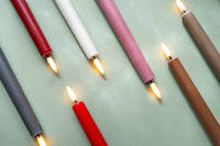 UYUNI Lighting(ウユニ・ライティング)は、デンマークのLEDで本物のキャンドル体験を再現するライティングブランドです。最大の魅力は、特許取得のユニークな「3Dフレーム(炎)」と、目で追ってしまうほど自然なフリッカー表現。灯りの芯が立ち上がるように見える立体的な炎は、見る角度によって表情が変わり、テーブル上のガラス器や壁面に繊細な陰影を落とします。見た目はクラシック、手触りはラグジュアリー、内部機構はイノベーティブ、伝統的なキャンドルの佇まいを、現代のテクノロジーで静かにアップデートしました。外装には本物のワックス(パラフィン加工の表面仕上げ)を用い、日中に置いてあるだけでも上質なオブジェのような存在感。夜は色温度のやさしい光で、北欧らしいhygge(ヒュッゲ)の空気を手軽にまとえます。インテリアの審美眼に応えるプロップとして完成度の高いLEDキャンドルです。