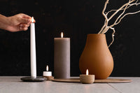 UYUNI Lighting(ウユニ・ライティング)は、デンマークのLEDで本物のキャンドル体験を再現するライティングブランドです。最大の魅力は、特許取得のユニークな「3Dフレーム(炎)」と、目で追ってしまうほど自然なフリッカー表現。灯りの芯が立ち上がるように見える立体的な炎は、見る角度によって表情が変わり、テーブル上のガラス器や壁面に繊細な陰影を落とします。見た目はクラシック、手触りはラグジュアリー、内部機構はイノベーティブ、伝統的なキャンドルの佇まいを、現代のテクノロジーで静かにアップデートしました。外装には本物のワックス(パラフィン加工の表面仕上げ)を用い、日中に置いてあるだけでも上質なオブジェのような存在感。夜は色温度のやさしい光で、北欧らしいhygge(ヒュッゲ)の空気を手軽にまとえます。インテリアの審美眼に応えるプロップとして完成度の高いLEDキャンドルです。