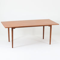 北欧モダンデザイン、180cm幅の大きな6人用ダイニングテーブルです。天板トップには見た目にも美しい上質なチーク突板を使用し、縁には贅沢に無垢材をジョイントしており、耐久力に加え曲線の美しさが際立っています。また、椅子を収納する際に干渉することが多い幕板ですが中央部を浅くすることで、干渉を軽減し、また見た目にも高級感を演出しています。通常安価な材質で仕上げられる幕板や天板裏面にも贅沢にチーク材天然木を使用しております。脚のポジションはやや内側にセットされスタイリッシュなデザインにも仕上がっています。