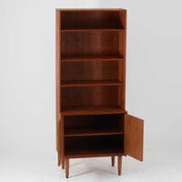 デンマークのHorsens Mobelfabrik社によるディスプレイシェルフは、温かみあるチーク材を使用した端正な佇まいが魅力の一台です。上段には可動棚が4枚備わっており、書籍やオブジェなどのディスプレイに最適です。下段は観音開きの収納扉付きで、見せる収納と隠す収納を両立。すっきりとした脚部構造と洗練された金属取手がアクセントとなり、北欧らしい実用性と美しさを兼ね備えたビンテージ家具です。