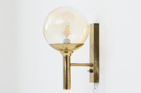 こちらは、Sven mejlstromによってデザインされた1960年代のウォールランプです。Sven mejlstromは、ノルウェーの照明デザイナーとして知られ、シンプルで機能的な美しさを追求したデザインを手掛けました。このランプは、真鍮とクリアガラスを組み合わせた美しいデザインが特徴で、ビンテージ品ならではの風合いが感じられます。大きなボール状のガラスシェードは光を柔らかく拡散し、空間に温かみと上品さを加えます。経年変化による真鍮部分の風合いも、時間を経た美しさを感じさせる魅力的な要素です。シンプルでありながらも印象的なこのウォールランプは、どんなインテリアにも調和し、エレガントなアクセントを与えてくれる一品です。