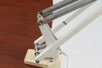 デンマークより買い付けたLouis Poulsen社製のデスクランプです。現行品では販売されていない希少なモデルで、シンプルながら機能的なデザインが特徴です。クランプタイプのため、置く場所を選ばず使用可能。最大板厚5cmまでの場所に取り付けることができるため、デスクやテーブルにしっかり固定してお使いいただけます。アーム部分は可動式で、光の角度を自由に調整できる設計になっており、デスクワークや読書、細かい作業にも最適です。ビンテージ品ならではの風合いが魅力的で、使い込まれたスチールの質感が独特の味わいを醸し出しています。