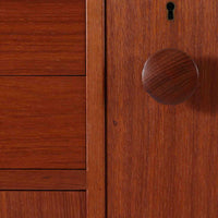 スウェーデンのBreox Moblerによるこちらのキッチンキャビネットは、温かみのあるチーク材を使用した北欧ビンテージ家具で、すっきりと直線的なフォルムと円形の木製取手が印象的な一台です。引き出し内には仕切り付きの収納も備え、カトラリーや小物の整理に便利です。扉内部は棚板付きで収納力にも優れ、中央の鍵付き扉はフラップ式でバースペースや食器収納としても活用できます。端正な佇まいと経年による木肌の深い色合いが空間に落ち着きを与える、実用性と存在感を兼ね備えた逸品です。