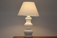 著名なデザイナー、Sidse Werner(シセ・ヴェルナー)による「BIBLIOTEK」のテーブルランプです。ペンダントランプはよく見かけますが、テーブルランプは非常に珍しいモデルです。ホルムガードならではの厚みのある高品質なガラスを使用しており、点灯するとシェードを通して柔らかな温かみのある光が広がり、空間を優雅に照らします。高さ64cmの大型サイズで存在感があり、リビングや書斎、ベッドサイドなど、あらゆるインテリアに美しく調和します。