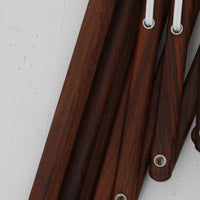 Erik Hansen(エリック・ハンセン)がデザインし、Le Klint(レ・クリント)より発表されたブラケットランプModel 332です。温かみのあるローズウッド材のアームと、職人技によるプリーツシェードの組み合わせが美しく、北欧らしい柔らかな光を演出します。アコーディオン式のアームは伸縮可能で、ベッドサイドやリビングの読書灯としても最適です。経年により味わいを増した木部とオリジナルシェードが、ビンテージならではの存在感を放ちます。ローズウッド材での展開はビンテージ品でのみ入手可能で、現行品には存在しない希少な一品です。