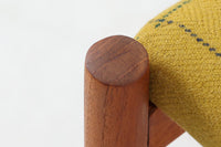 チーク材のフレームにイエロー系ファブリックを張ったスツールは、Spottrup Mobelfabrikによる北欧ビンテージ品で、緩やかなカーブを描く座面が身体にやさしくフィットし、オットマンとしてはもちろん玄関先やサイドチェア代わりにも重宝します。シンプルながらも細部まで丁寧に仕上げられたつくりからは、デンマーク家具らしい確かな品質と経年による風合いが感じられます。