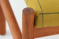 チーク材のフレームにイエロー系ファブリックを張ったスツールは、Spottrup Mobelfabrikによる北欧ビンテージ品で、緩やかなカーブを描く座面が身体にやさしくフィットし、オットマンとしてはもちろん玄関先やサイドチェア代わりにも重宝します。シンプルながらも細部まで丁寧に仕上げられたつくりからは、デンマーク家具らしい確かな品質と経年による風合いが感じられます。