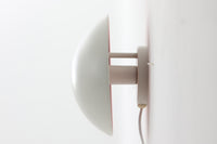 もともとへニングセンが自宅寝室のためにデザインし、1961年に発表したウォールライトで、温かみのある光を生むためシェード内面はローズ色に塗装されています。壁面でソフトな間接照明が得られ、広がり感のある空間をつくりだします。シェードが約60度可動するため、ベッドやソファーサイドの読書灯としても適しています。