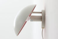 もともとへニングセンが自宅寝室のためにデザインし、1961年に発表したウォールライトで、温かみのある光を生むためシェード内面はローズ色に塗装されています。壁面でソフトな間接照明が得られ、広がり感のある空間をつくりだします。シェードが約60度可動するため、ベッドやソファーサイドの読書灯としても適しています。