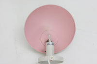 もともとへニングセンが自宅寝室のためにデザインし、1961年に発表したウォールライトで、温かみのある光を生むためシェード内面はローズ色に塗装されています。壁面でソフトな間接照明が得られ、広がり感のある空間をつくりだします。シェードが約60度可動するため、ベッドやソファーサイドの読書灯としても適しています。