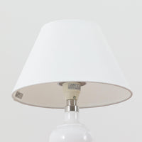 Anne Grethe von Halling-KochがRoyal Copenhagenより発表したモデル「Roma」のテーブルランプです。ガラスベースの柔らかな曲線が美しく、シェードにはリネンが用いられており、点灯時には温かみのある光が空間を優しく包み込みます。高さ34cmと程よいサイズ感で、ベッドサイドやリビングのアクセント照明としても最適です。デンマーク製ならではの洗練された造形と、経年を重ねたビンテージならではの趣が調和した一品です。