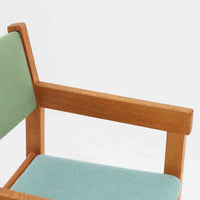 Hans J. Wegner(ハンス・J・ウェグナー)がデザインし、Getama(ゲタマ)が製造を手掛けたGE151アームチェアです。オーク材による直線的で端正なフレームに、ゆるやかにカーブした背もたれと座面を組み合わせた、軽快で機能的な佇まいが魅力。幅のあるアームは木の質感を存分に感じられ、長年の使用による風合いもビンテージならではの味わいです。ダイニングや書斎のほか、ゆったりと腰掛けるラウンジチェアとしても取り入れやすい一脚です。