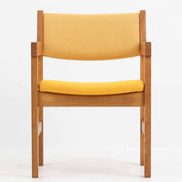 Hans J. Wegner(ハンス・J・ウェグナー)がデザインし、Getama(ゲタマ)が製造を手掛けたGE151アームチェアです。オーク材による直線的で端正なフレームに、ゆるやかにカーブした背もたれと座面を組み合わせた、軽快で機能的な佇まいが魅力。幅のあるアームは木の質感を存分に感じられ、長年の使用による風合いもビンテージならではの味わいです。ダイニングや書斎のほか、ゆったりと腰掛けるラウンジチェアとしても取り入れやすい一脚です。