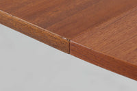 こちらはスウェーデンで買い付けたエクステンションダイニングテーブルです。天板は、珍しいラウンドスクエアの形状を採用しており、柔らかな印象と洗練されたデザインが魅力です。脚部は左右に開く構造で安定感があり、幕板は中央部分に向かってカットされているため、椅子の出し入れや座り心地にも配慮されています。また、来客時には付属の拡張板を使用することで、天板を簡単に広げられ、大人数での食事にも対応可能です。使い手の利便性を追求した設計が光る一品です。素材には、良質なチーク材とオーク材を使用しており、木目の美しさや温かみを感じられます。北欧家具ならではの高いデザイン性と実用性を兼ね備えたダイニングテーブルをぜひお楽しみください。