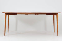 こちらはスウェーデンで買い付けたエクステンションダイニングテーブルです。天板は、珍しいラウンドスクエアの形状を採用しており、柔らかな印象と洗練されたデザインが魅力です。脚部は左右に開く構造で安定感があり、幕板は中央部分に向かってカットされているため、椅子の出し入れや座り心地にも配慮されています。また、来客時には付属の拡張板を使用することで、天板を簡単に広げられ、大人数での食事にも対応可能です。使い手の利便性を追求した設計が光る一品です。素材には、良質なチーク材とオーク材を使用しており、木目の美しさや温かみを感じられます。北欧家具ならではの高いデザイン性と実用性を兼ね備えたダイニングテーブルをぜひお楽しみください。